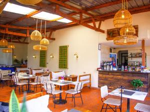 坎帕拉Explorers Hub的一间带桌椅的餐厅和一间酒吧