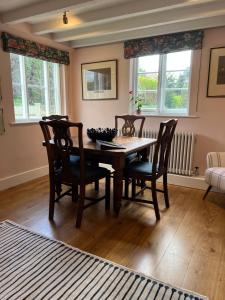 BredonLuxury Cottage with Garden的一间带木桌和椅子的用餐室