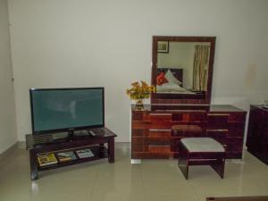 卢萨卡Waterfalls hotel (Lusaka)的客厅配有电视、椅子和镜子