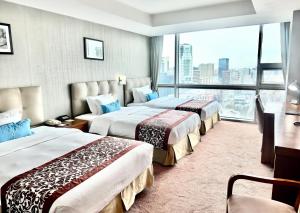 乌兰巴托蓝天大厦酒店的酒店客房设有三张床和大窗户