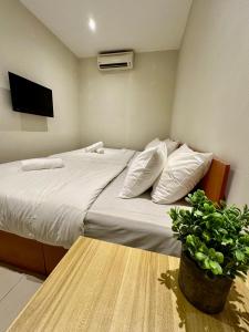 吉隆坡Swing & Pillows - KL Pekeliling formerly known as Swiss Cottage Hotel的一间卧室配有一张床和盆栽植物