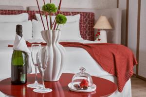 马略卡岛帕尔马波萨达特拉散塔精品酒店的一张带桌子的床铺,配有一瓶葡萄酒和眼镜
