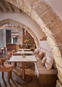 马略卡岛帕尔马波萨达特拉散塔精品酒店的一间设有桌子、沙发和石墙的客房