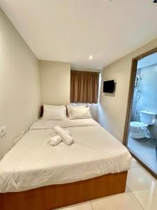 吉隆坡Swing & Pillows - KL Pekeliling formerly known as Swiss Cottage Hotel的卧室配有一张白色大床和浴室
