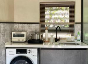 青岛禾煦的家-和煦 HX house的厨房配有洗衣机和微波炉。