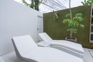 塞米亚克The Lavana Seminyak Loft 360 - 1 Bedroom Villa with Private Pool的阳台上摆放着两把白色椅子和一棵植物