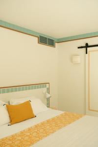 卡普费雷沙丘酒店的一间卧室配有一张黄色枕头的床
