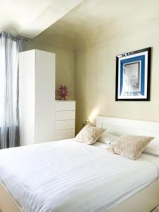 阿斯蒂ComeCasa San Secondo White的一间卧室配有一张带白色床单的大床