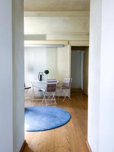 阿斯蒂ComeCasa San Secondo White的一间客厅,配有蓝色地毯和一张桌子
