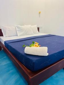 阿鲁甘湾Baywatch Arugambay的蓝色的床,上面有一条毛巾