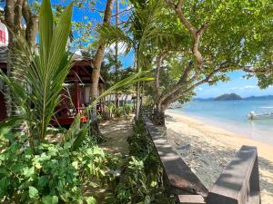 爱妮岛双宝石海滩度假村的海滩上有长凳,树木和水