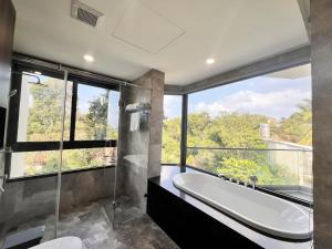 富国Le Anh Hotel的带浴缸的浴室和大窗户