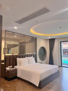 富国Le Anh Hotel的卧室设有一张大白色的床和大型天花板