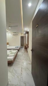 乌贾因Hotel Prakasham的走廊上设有两张床,房间设有一扇门
