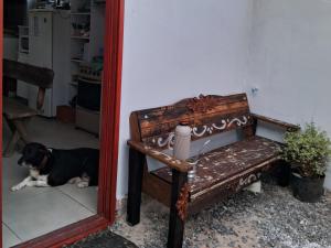 特拉曼达伊Pousada Luz Beira mar的狗躺在板凳旁边的地板上