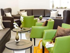 特里尔Ibis Styles Trier City的客厅配有绿色的椅子、桌子和沙发