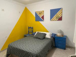 阿雷西费La Buganvilla rooms的卧室配有一张床,墙上挂有绘画作品