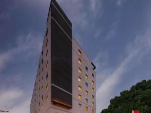 哥印拜陀ibis Coimbatore City Centre - An Accor Brand的一座高大的黑色建筑,窗户在建筑的一侧