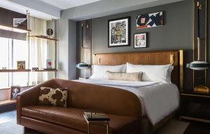 达拉斯Thompson Dallas, by Hyatt的一间卧室配有一张床和一张皮沙发