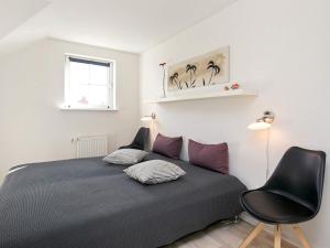 博恩瑟8 person holiday home on a holiday park in Bogense的卧室配有床、椅子和窗户。