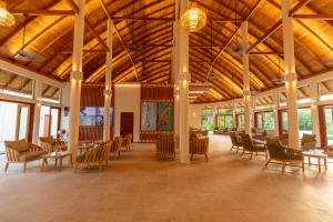 迪弗西Meeru Maldives Resort Island的大房间设有木制天花板和桌椅