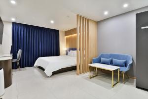庆州Hotel Palace Gyeongju的酒店客房,配有一张床和一张蓝色椅子