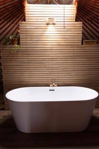 JargalantYeruu lodge的浴室设有白色浴缸,浴室设有木墙