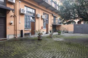 米兰Moderno e Confortevole Loft tra Navigli e Bocconi的建筑前方种有盆栽植物的庭院