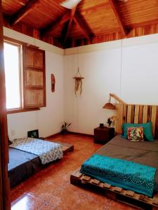 CabuyaCasa Qi Boho B&B的一间带两张床的卧室,位于木天花板的房间