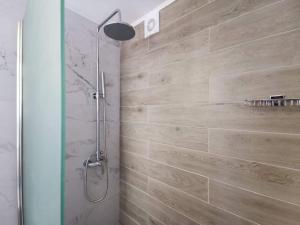 ParánimfoiSunrise Luxury Seaside Apartment的带淋浴的浴室和木墙