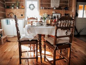 WyszkiNa wsi Zalesie 53的一间用餐室,配有一张带白色桌布的桌子