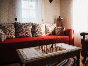 WyszkiNa wsi Zalesie 53的客厅配有红色沙发及棋盘