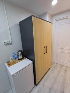 伊斯坦布尔White Palace Hotel的厨房配有黑色和木质橱柜,旁边设有冰箱
