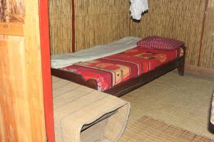NyakinamaRed Rocks Rwanda - Bamboo Cottage的小房间设有一张床和一张桌子
