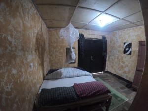 NyakinamaRed Rocks Rwanda - Campsite Guesthouse的一间小卧室,卧室内配有一张床铺