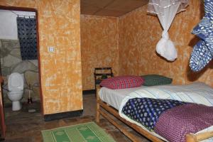 NyakinamaRed Rocks Rwanda - Campsite Guesthouse的小房间设有床和卫生间