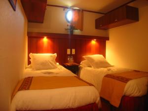 艾格-莫尔特Bateau Le Phénicien的酒店客房设有两张床,墙上有灯