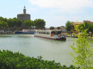 艾格-莫尔特Bateau Le Phénicien的船停靠在城市附近的河流上