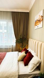 阿拉木图ЖК 4YOU Comfort的一间卧室配有红色和白色枕头的床