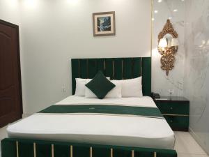 拉合尔Golden One Hotel的一张带绿色床头板的床