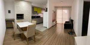 佩洛塔斯Apartamento acqua的厨房以及带桌椅的起居室。
