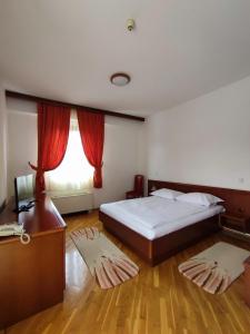 萨拉热窝Hotel M3的一间卧室配有一张床、一张书桌和一个窗户。