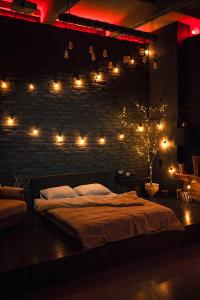 尼古拉耶夫Лофт студия с панорамной террасой的一间卧室,卧室的砖墙上配有一张带灯的床铺