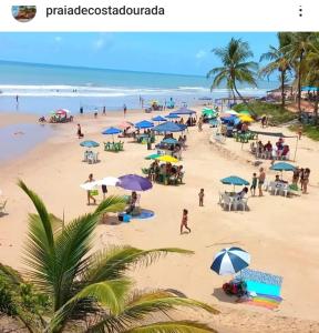 Costa DouradaCasas lindas no paraiso!的海滩上有人和遮阳伞海滩