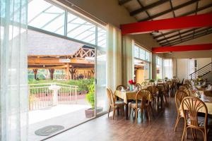 GuluBomah Hotel Limited的餐厅设有桌椅和大窗户。
