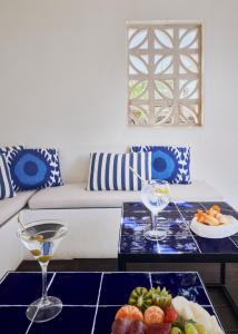 马略卡岛帕尔马波萨达特拉散塔精品酒店的客厅配有沙发和带酒杯的桌子