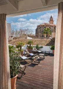 马略卡岛帕尔马波萨达特拉散塔精品酒店的阳台配有椅子,享有建筑的景致。