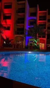 吉布提吉布提莱斯金合欢酒店的一座游泳池,在晚上在建筑物前