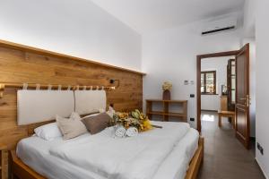 蒙特普齐亚诺Terra Antica Apartments - La Fornace的一间卧室配有一张白色大床,床上有鲜花