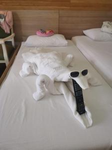 锡德CLUB GRAND SIDE的一只塞满了大象的躺在床上,有遥控器
